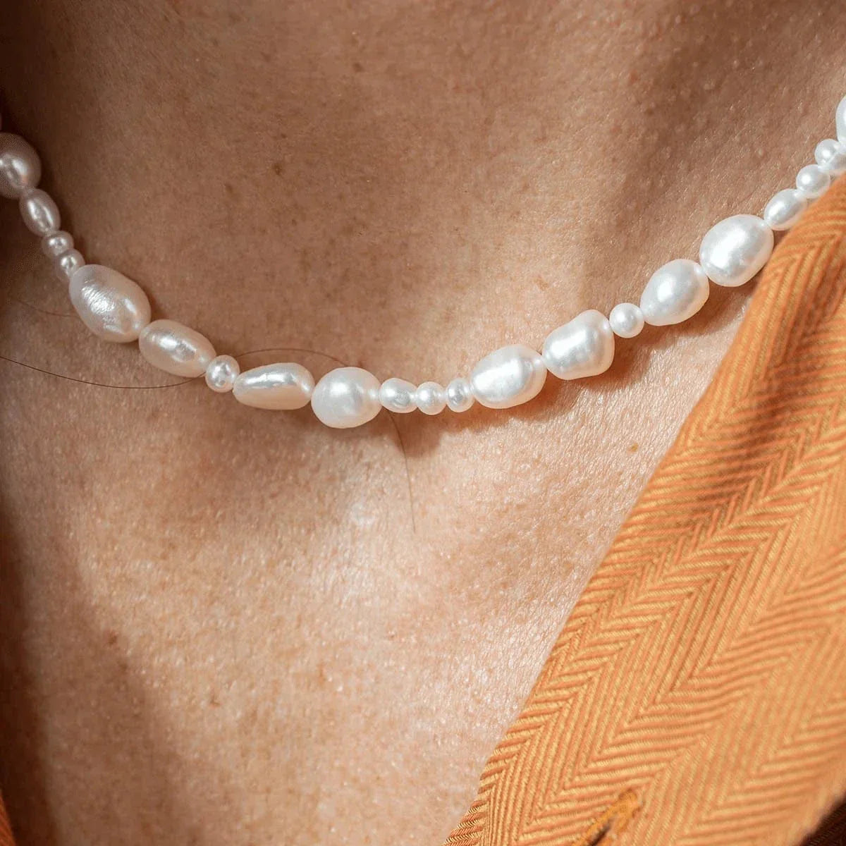 Vincent Venus Conspiracy Gold Plated Pearl Necklace Shown close to a neck, irregular white pearls. Model VJ087