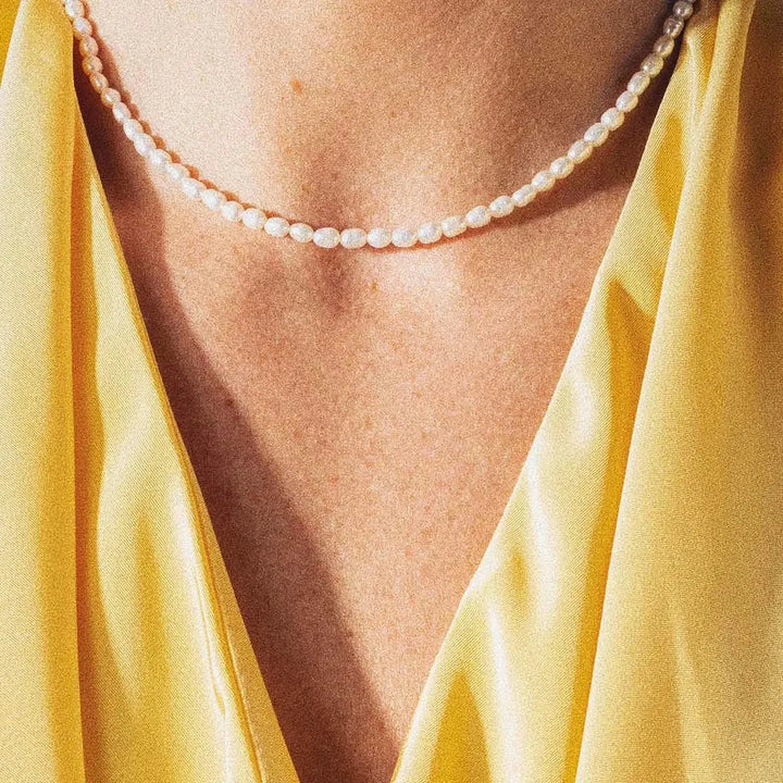 Vincent Venus gold-plated pearl necklace VJ082, worn by woman in yellow satin blouse. Model VJ082