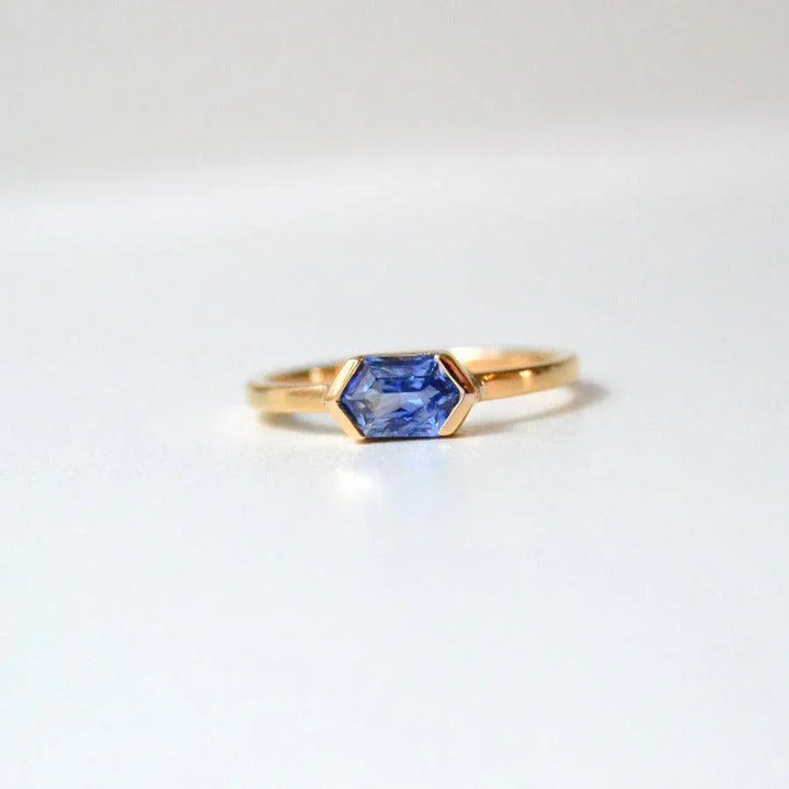 Anpe Atelier Customized Ring with blue sapphire shown close up, elegant in gold with hexagonal blue sapphire stone. Model 27-blasafir-001-1