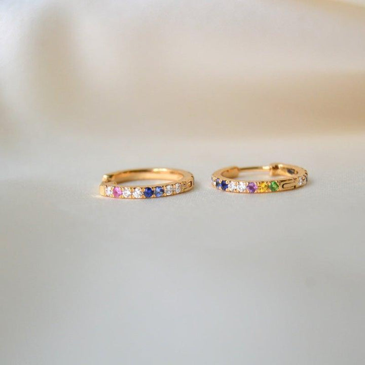 anpe atelier kyra creoles 18kt gold with brilliants and precious stones, two earrings with colored stones lying on a light background. Model 23-2-customized-1