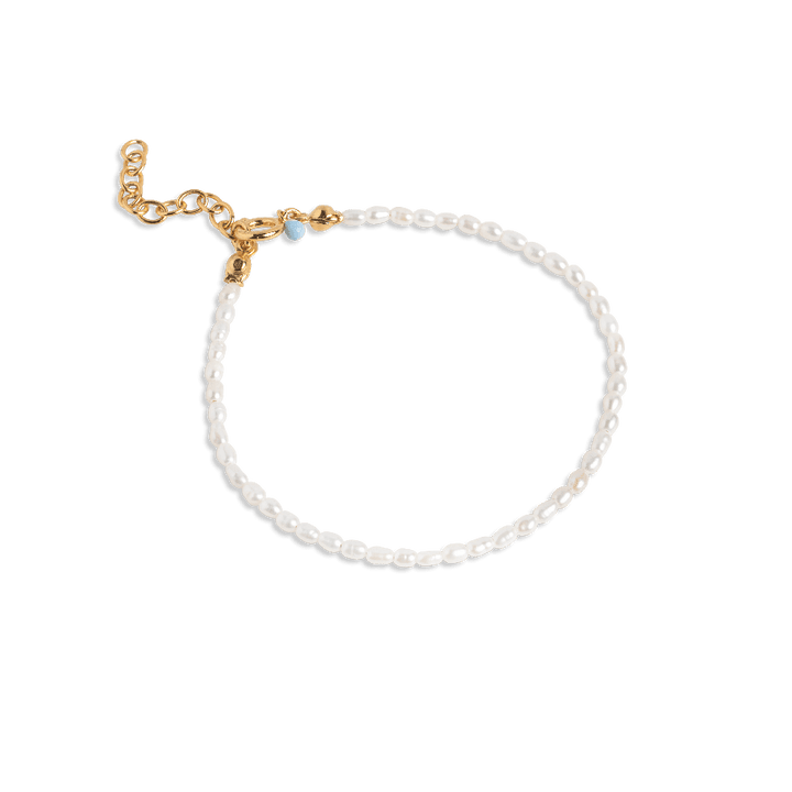 enamel erna pearl bracelet with white freshwater pearls and gold-coloured chain lock on a blue background. Model b110g-b110g-1
