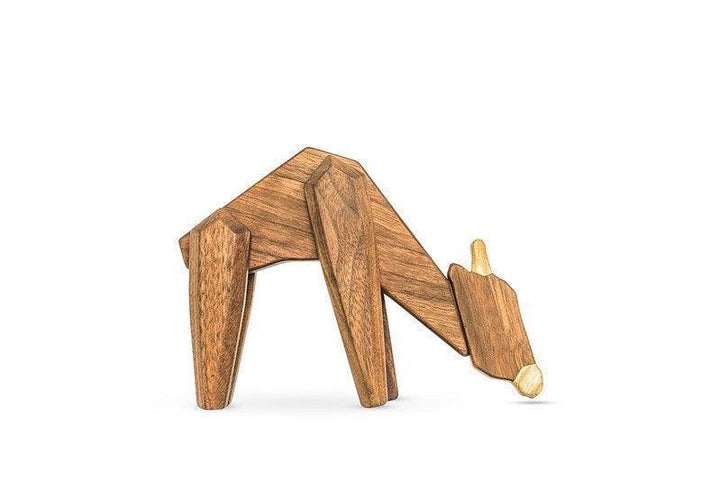 Fablewood Giraffe, an elegant figure of light and dark wood, stands bent downwards on a white background. Model 1027-2