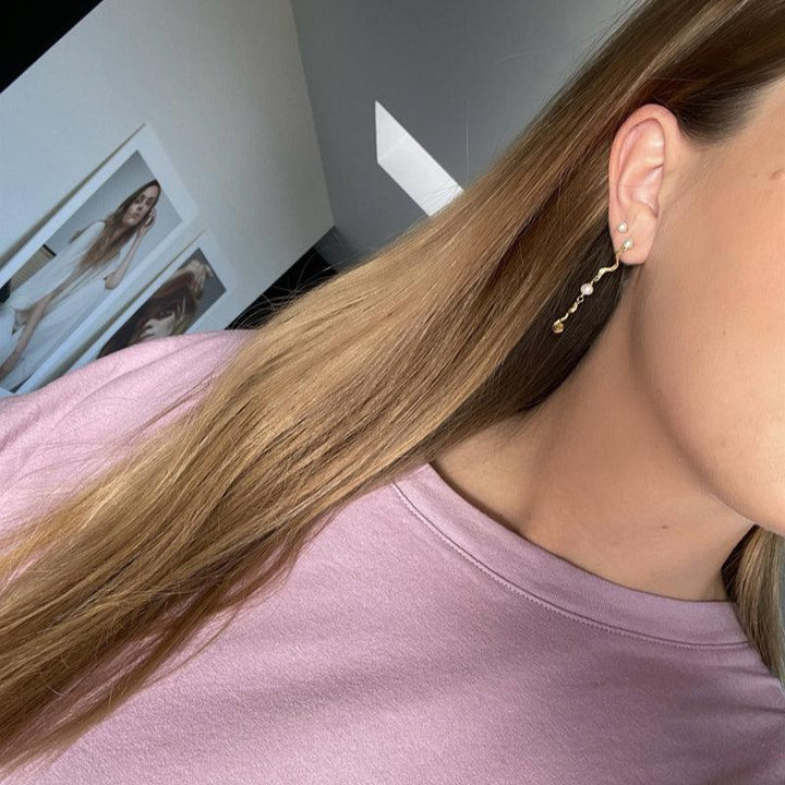Jeberg Jewelery Ocean Pearl gold plated earring shown on ear, elegant design with pearl and gold details. Model 51720-2