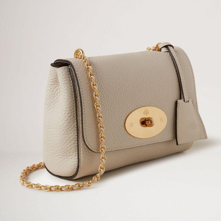 Mulberry Bag Lily Chalk Heavy Grain shows an elegant shoulder bag in light grey, heavy leather with gold chain. Model HH6950736W160