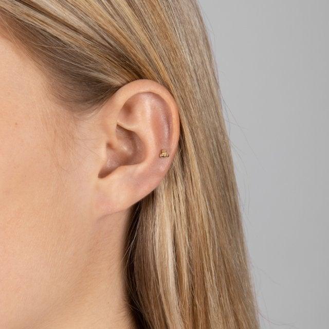 Nordahl Andersen 14kt piercing, small gold detail shown in woman's ear, Model 314002-5-2