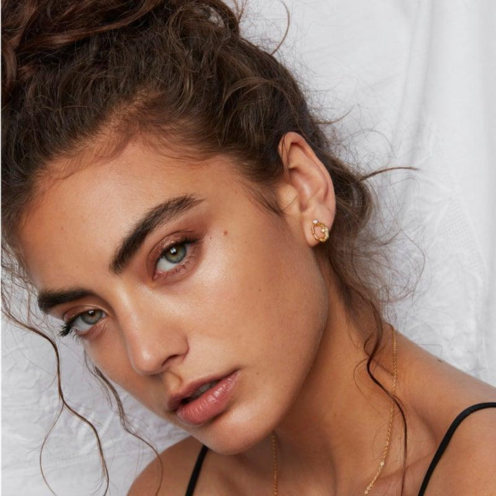 Polar Jewelry Aurora Gold Plated Earring single is shown worn in the ear, gold look with clear stones. Model aur-st-gd-cz-00407-2