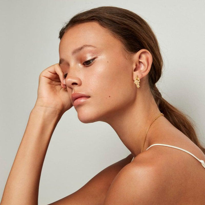 The Princess on the Pea ear ring worn by model, shown in gold tone, elegant and modern. Model pri-st-gd-wz-00310-2