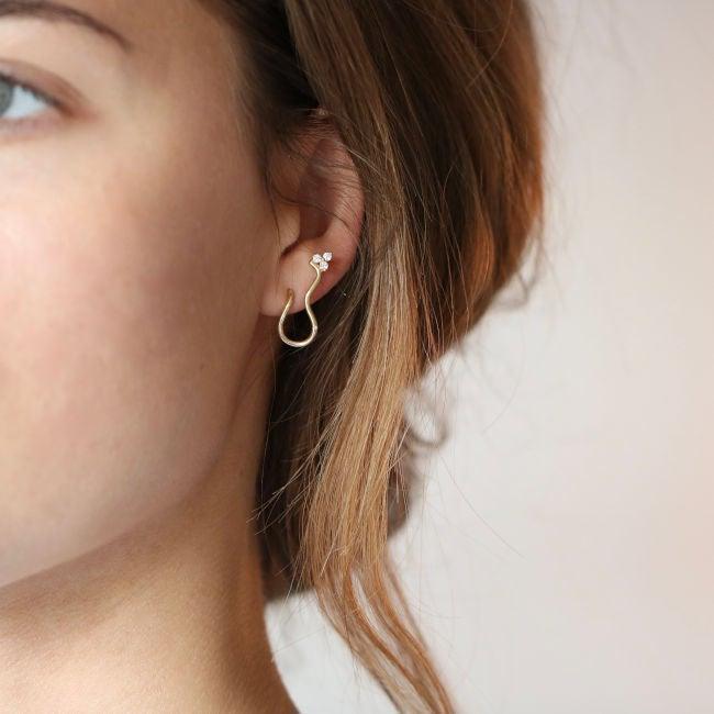 ro copenhagen 18kt freyd wave diamond stud earring left seen on the ear, elegant wavy gold and diamond design. Model 108104-2
