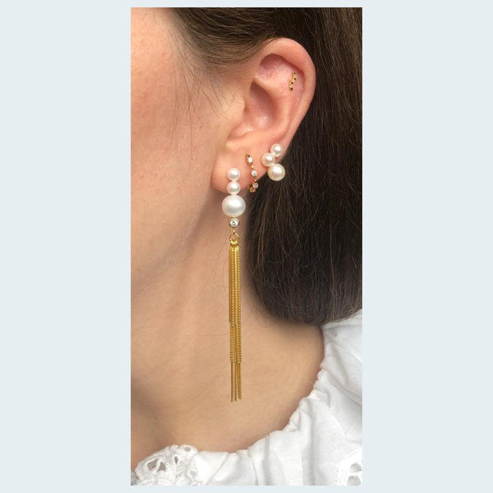 Baila Perle Earring with chains is shown worn on ear, pearls and gold colored chains. Model fw2027-fw2027