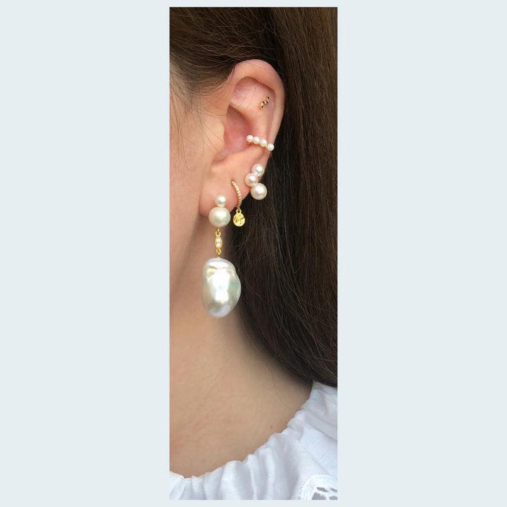 Cherie Perle Earring shows the ear with a large baroque pearl and several small pearls in a gold look. Model FW2014-FW2014-2