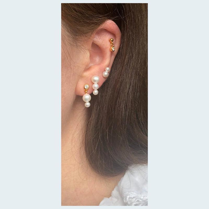 Deux Perle Orestik showed elegant gold earrings decorated with white pearls on the model's ear. Model ss2017-ss2017-2