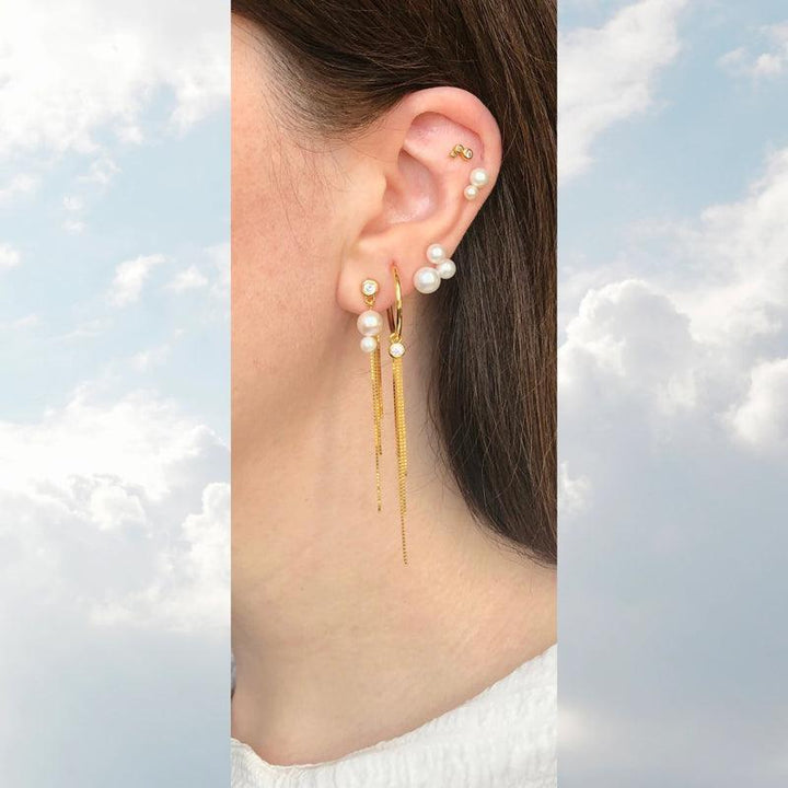 Tassel Charm FW2123 with golden chains and white pearls worn in the ear, Model FW2123-2.