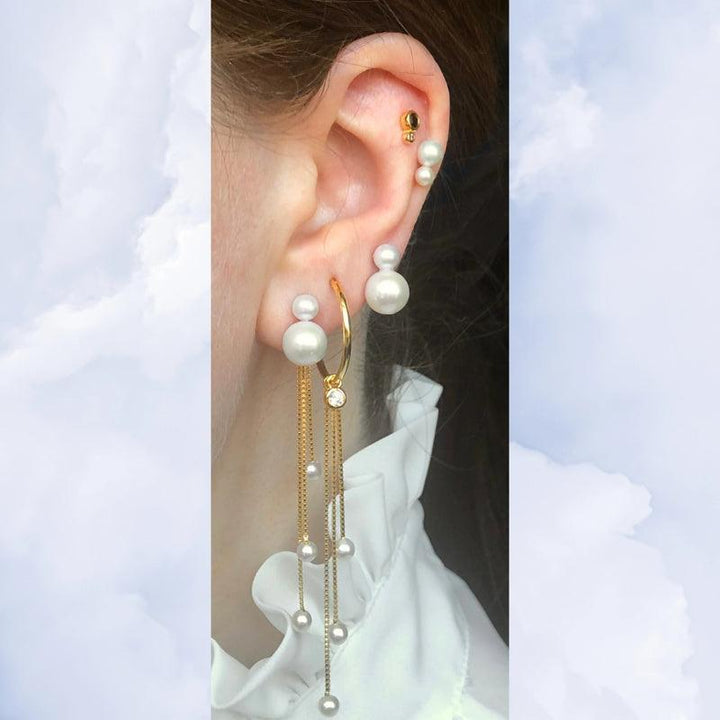 Tassel Pearl Charm SS2223 shows an ear with gold earring, white pearls and long gold chains. Model SS2223-2